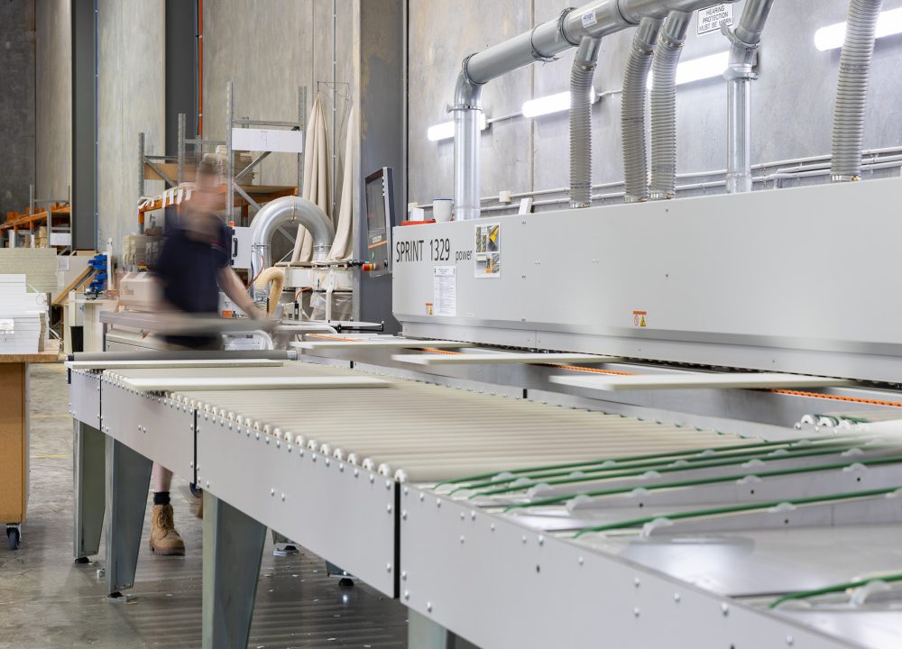 A person cutting components of a kitchen in a Kitchen Manufacturing plant