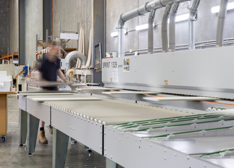 A person cutting components of a kitchen in a Kitchen Manufacturing plant