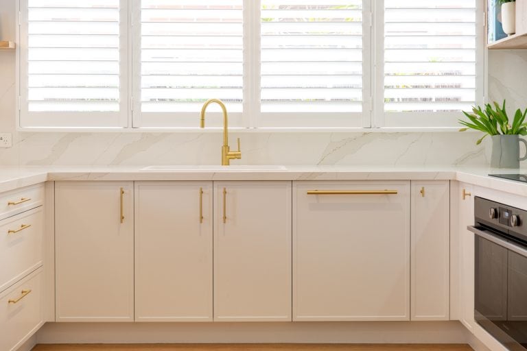 U shaped white kitchen with brass handles and brass tapware