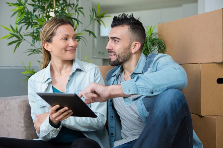 Female and male looking at an ipad in their kitchen space
