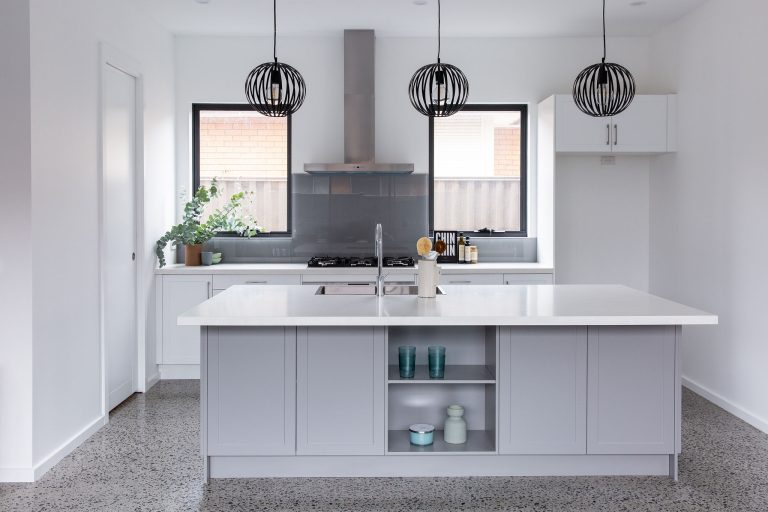 Large kitchen renovation with shaker cabinetry in island bench and two black windows