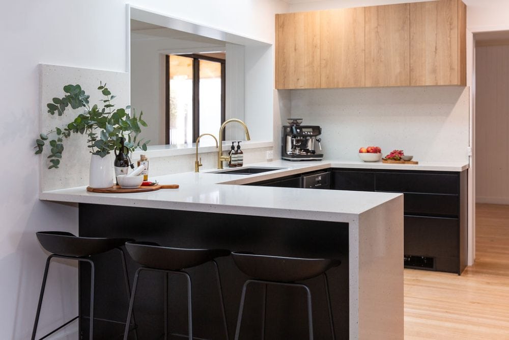 black and timber u shape kitchen with kitchen island bench and timber flooring