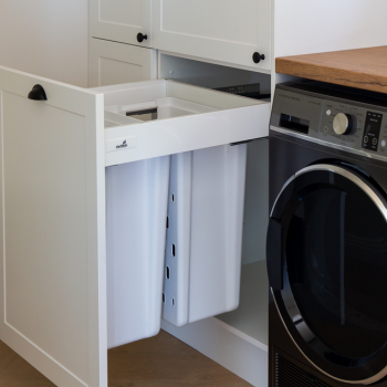 Double laundry hampers in white hampton laundry next to a washing machine