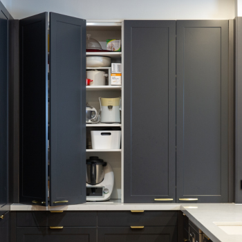 Appliance cabinet displaying wingline systems of sliding black cabinetry doors