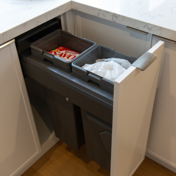 Small double bin system with grey bins in white hampton style kitchen
