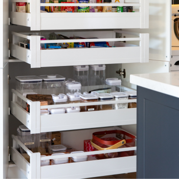 Four extra large pull out pantry shelves for storage in a kitchen