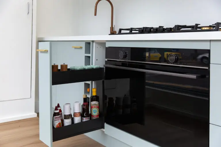 Pull out spice rack in galley kitchen next to a black oven