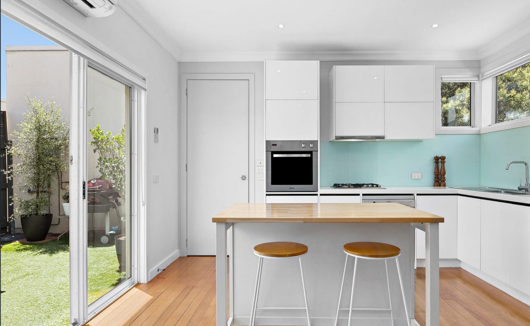 White kitchen with green glass splashback designed back in 2011