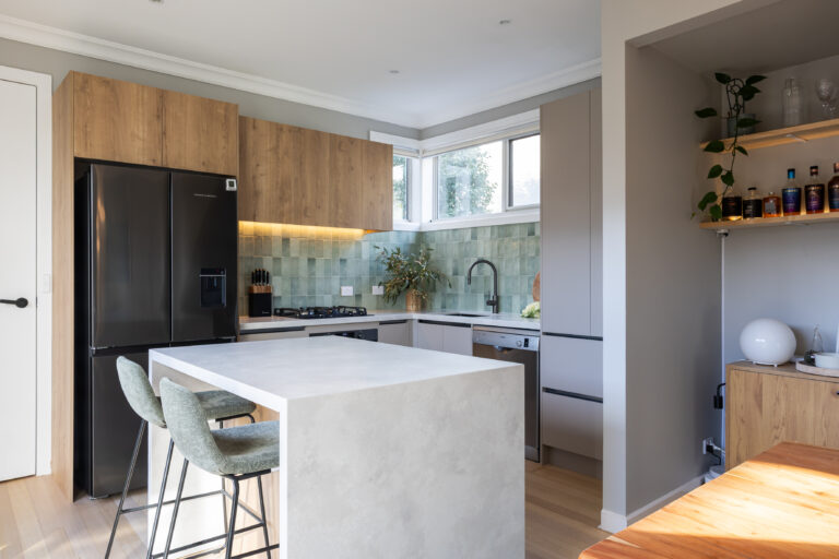 U Shaped kitchen in Yarraville, Melbourne with large standalone stone island bench and cream cabinetry with oak overheads to create warmth