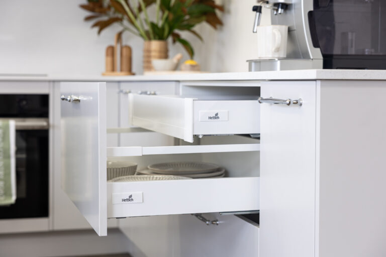 White kitchen featuring a kitchen drawer with a pull out concealed drawer