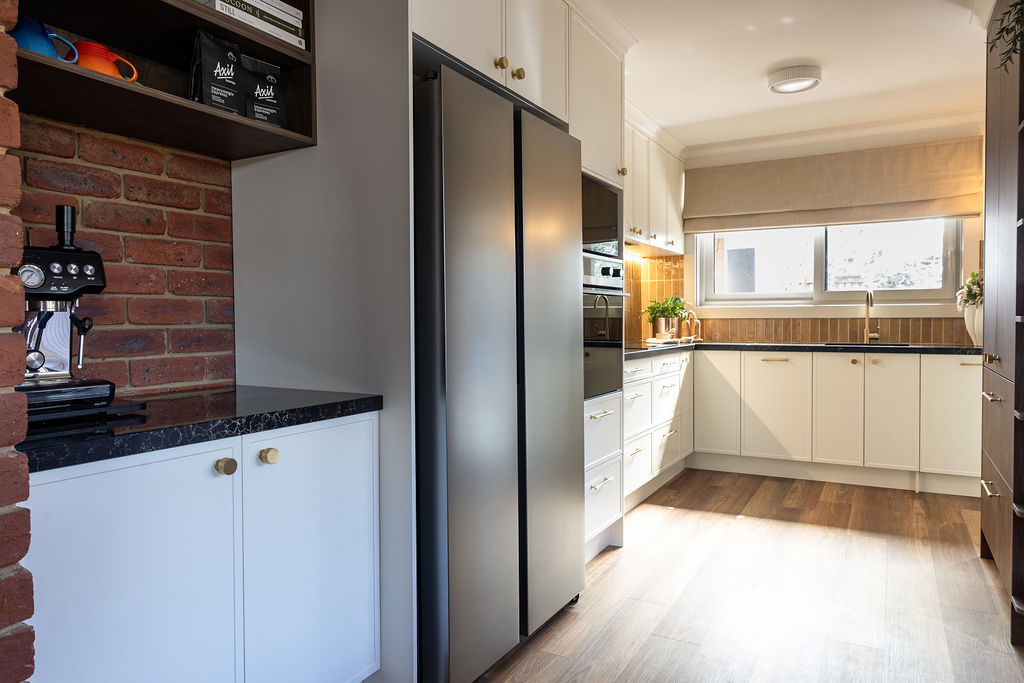 U shaped kitchen featuring parchment Hampton style cabinetry matched with Sepia Walnut overhead and pantry with black benchtops