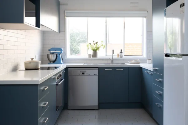 Blue colour kitchen cabinetry in u shape kitchen with blue mixmaster and cream pot on cooktop