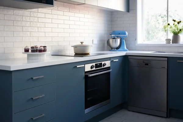 Kitchen with blue cabinetry displaying underbench oven and induction cooktop with mixmaster cakes and pot on cooktop