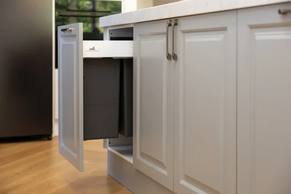 Galley style kitchen with white carrington style cabinetry with chrome handles with pull out grey hettich bins with herringbone timber flooring