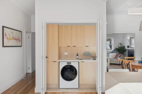 Laundry renovation with oak timber laminate cabinetry with sliding doors to close off