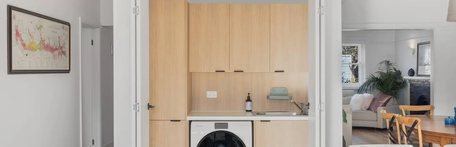 Laundry renovation with oak timber laminate cabinetry with sliding doors to close off
