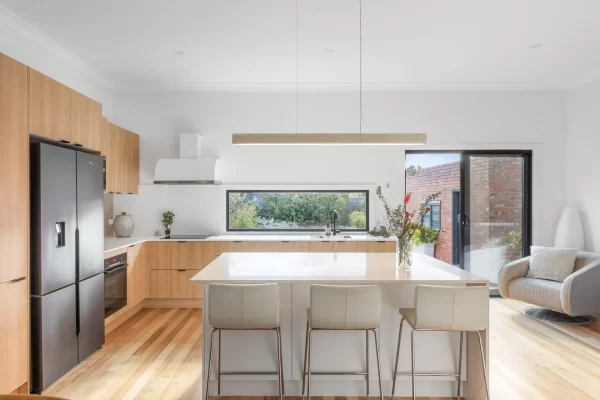 Oak timber laminate and white kitchen cabinetry with a standalone island bench in a u shaped kitchen