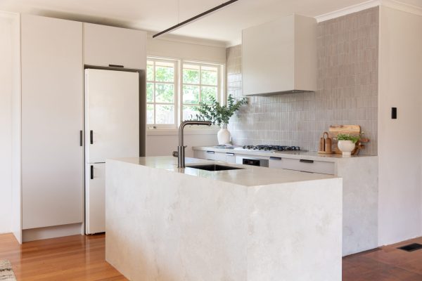 Galley style kitchen with oyster grey cabinetry and large standalone marbled island bench