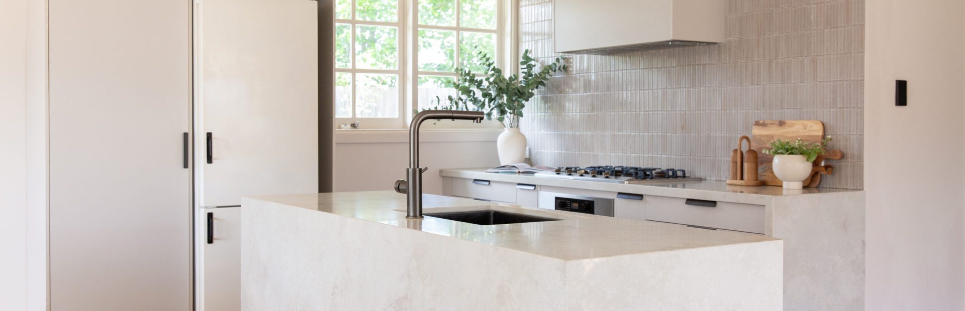 Galley style kitchen with oyster grey cabinetry and large standalone marbled island bench