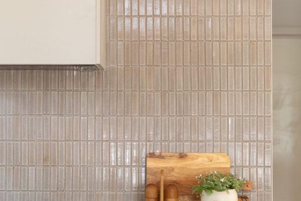 Kitchen benchtop displaying stone and chopping board, timber salt and pepper and plan on benchtop