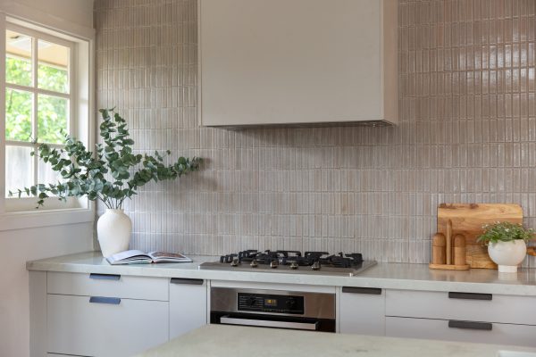 Kitchen cabinetry featuring profile black handles on the top of cabinetry