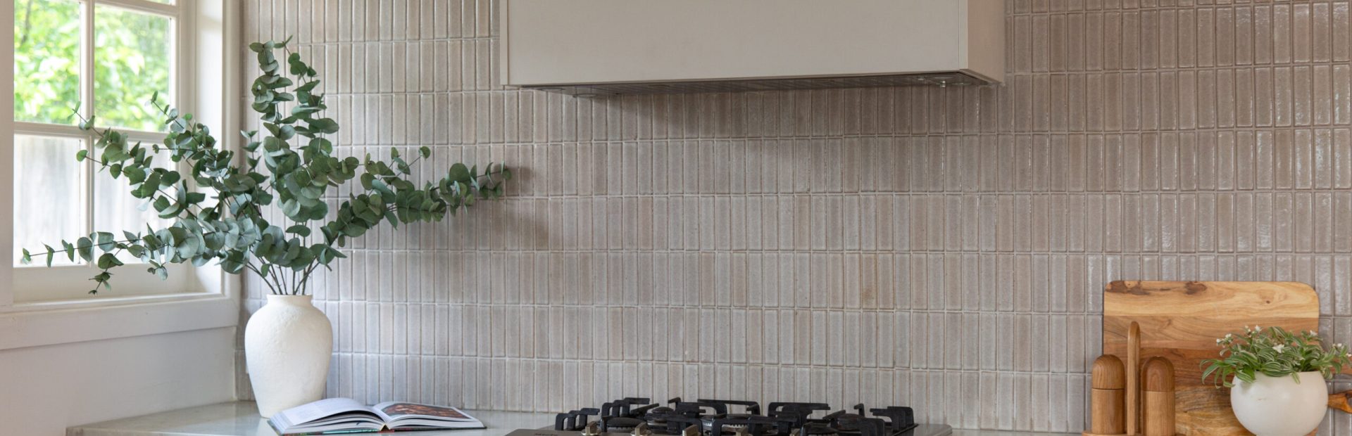 Kitchen cabinetry featuring profile black handles on the top of cabinetry