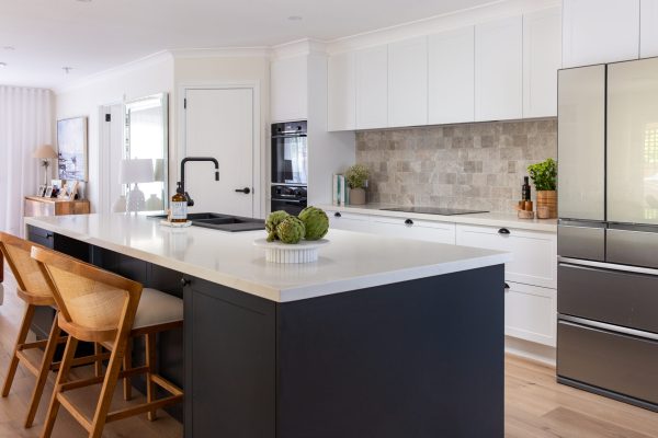 White and dark grey galley style kitchen with grey tiled splashback and large island bench