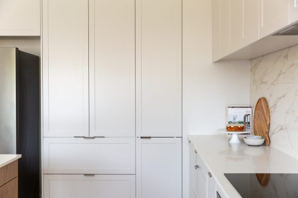 Light grey kitchen cabinetry doors featuring a pantry with pot drawers below