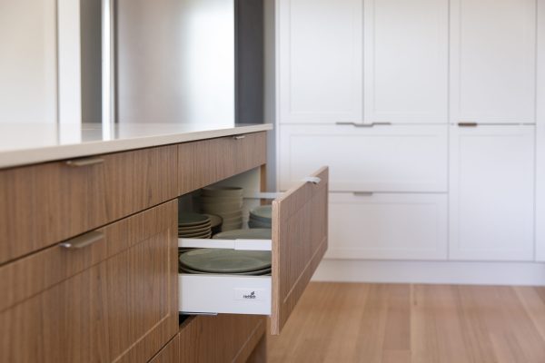 White and oak timber kitchen cabinetry with open drawer and profile brushed nickel handles