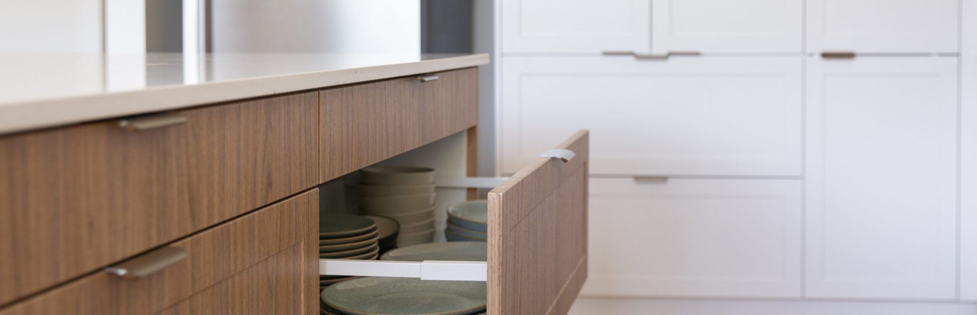 White and oak timber kitchen cabinetry with open drawer and profile brushed nickel handles