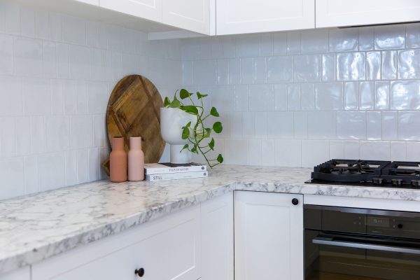 Corner kitchen cabinetry with white splashback