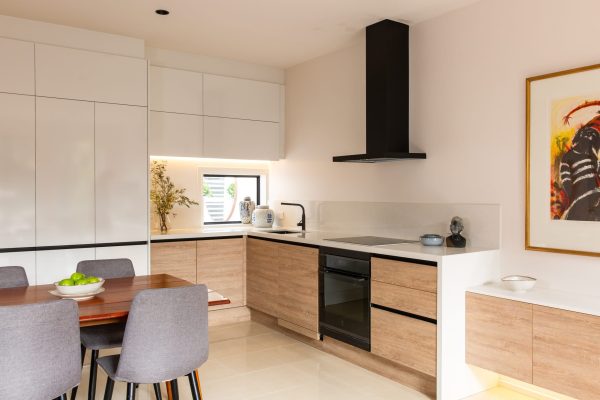 U shaped kitchen with timber laminate cabinetry and black oven and black rangehood