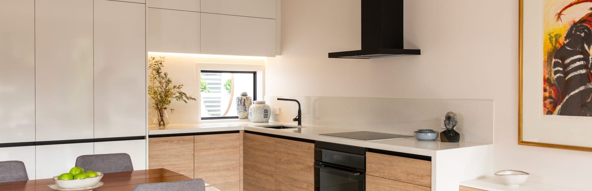 U shaped kitchen with timber laminate cabinetry and black oven and black rangehood