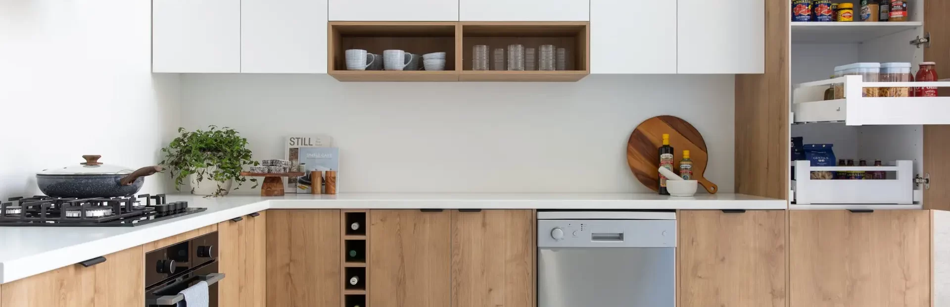 Timber style kitchen cabinetry in u shape with white overhead cabinetry