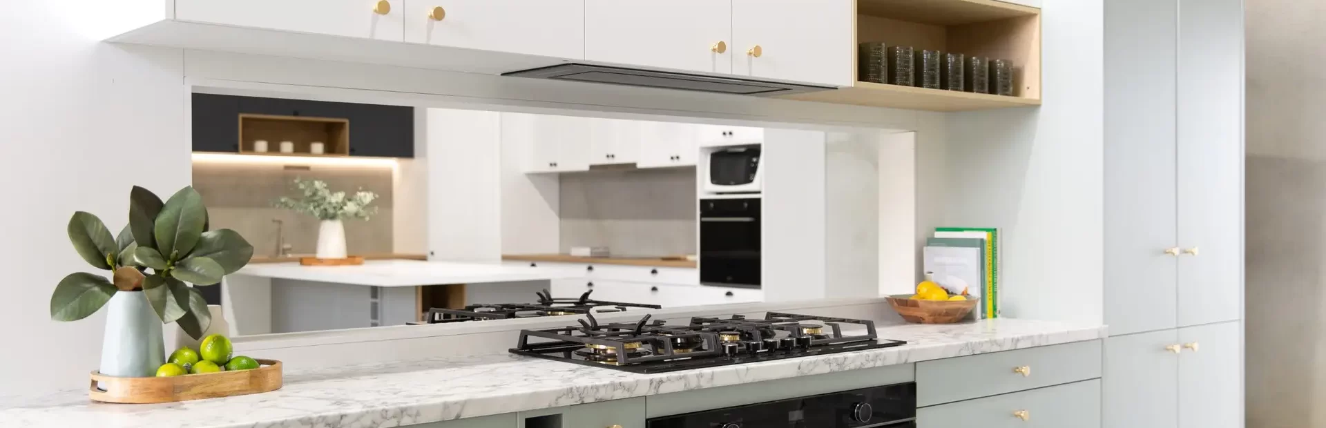 galley kitchen with green cabinetry and white overhead cabinetry with open shelf in timber style