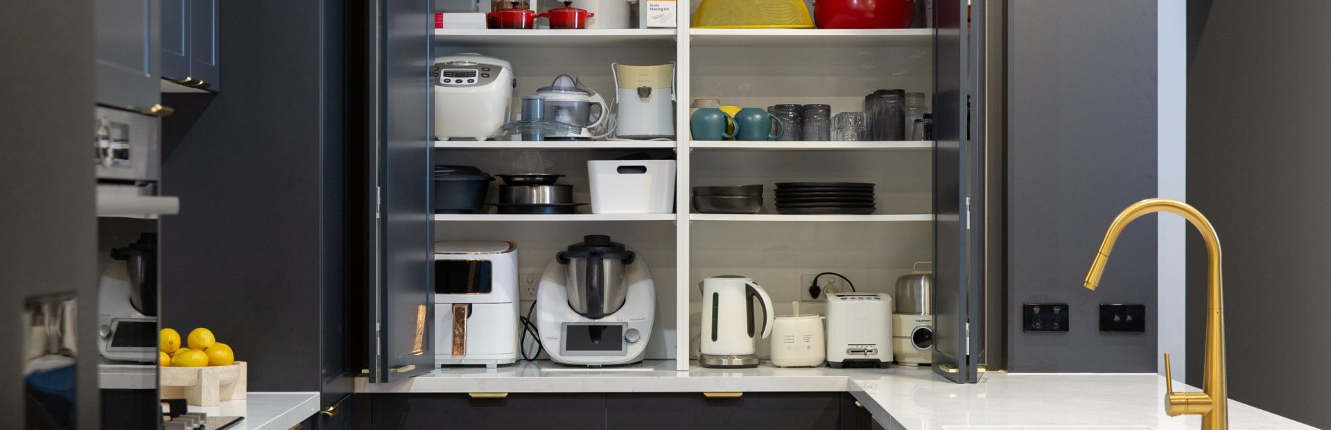 Double appliance cupboards open displaying thermomix and small appliances in a terril shaker style kitchen