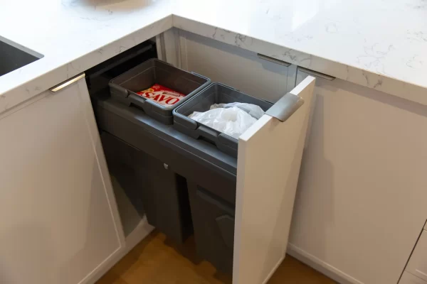 Compact size double bin system in hampton style kitchen with white kitchen cabinetry and white stone benchtops