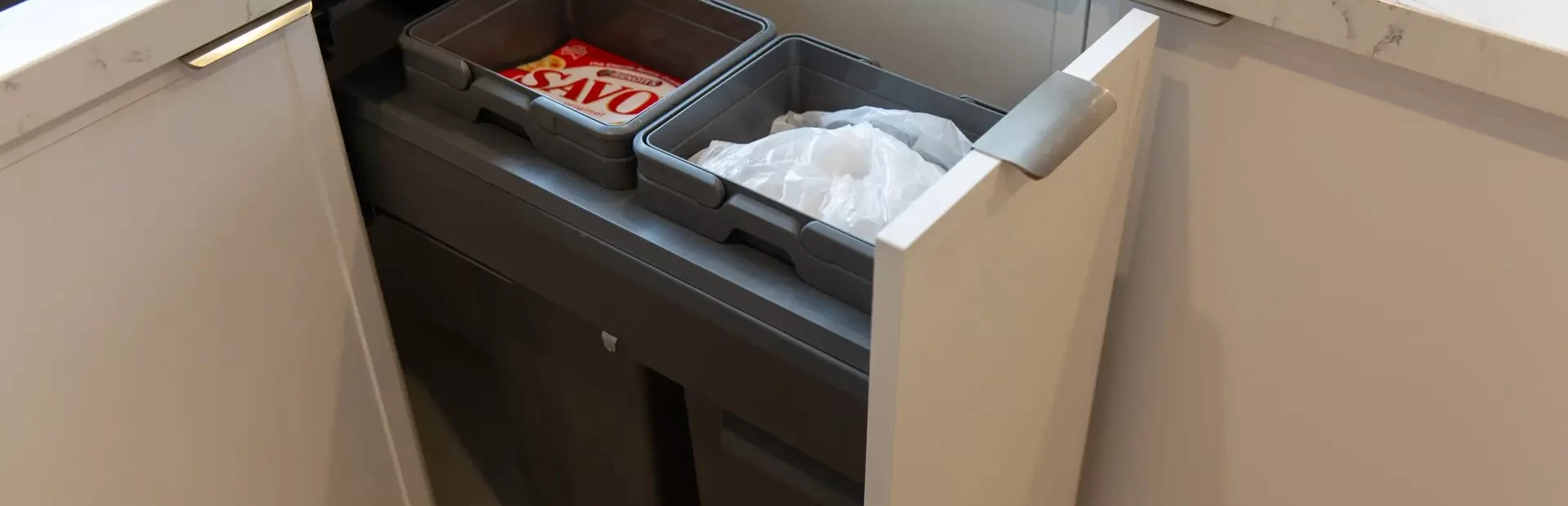 Compact size double bin system in hampton style kitchen with white kitchen cabinetry and white stone benchtops