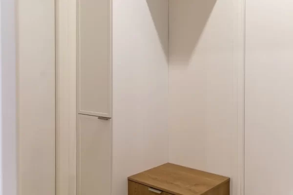 Mudroom featuring timber and white cabinetry with broom cabinet and seat to pop off shoes before entering home