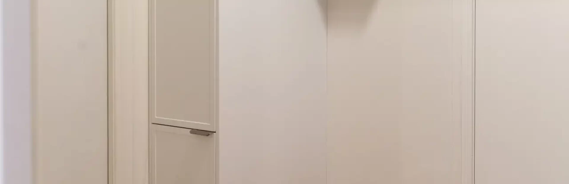 Mudroom featuring timber and white cabinetry with broom cabinet and seat to pop off shoes before entering home