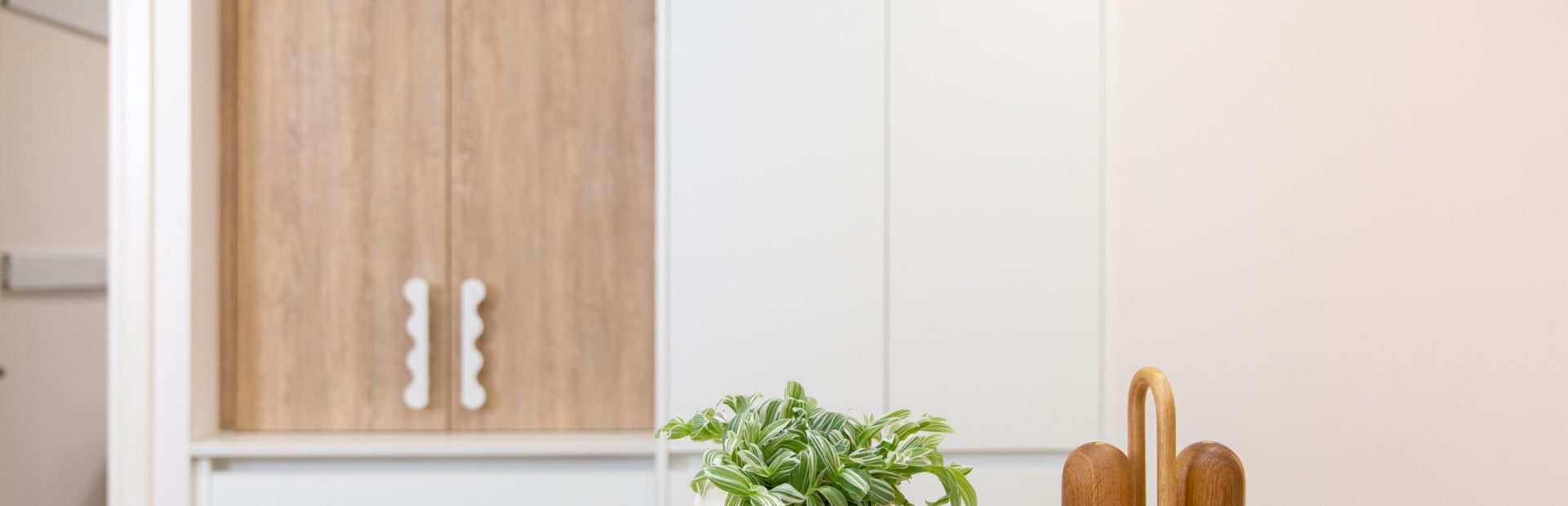 Kitchen displaying oak style appliance cabinet and timber chopping board featuring Country Road Butter and salt and pepper homewares