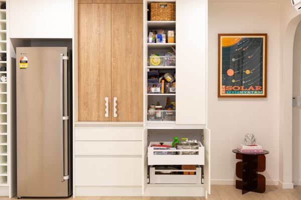 Double pantry featured in this kitchen using timber and white cabinetry with pull out internal drawers displaying pantry items