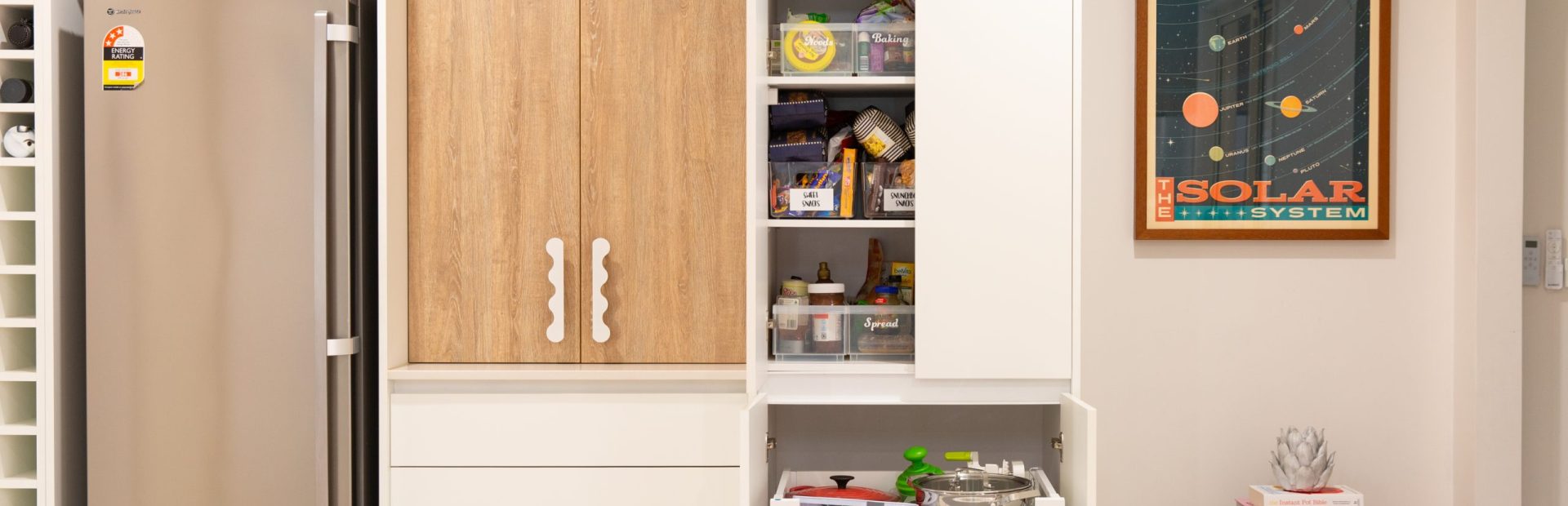 Double pantry featured in this kitchen using timber and white cabinetry with pull out internal drawers displaying pantry items