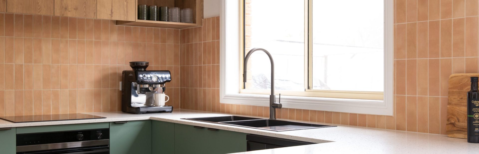 U shaped kitchen featuring green kitchen cabinetry and timber laminate overheads with an open shelf and coffee machine on stone bench