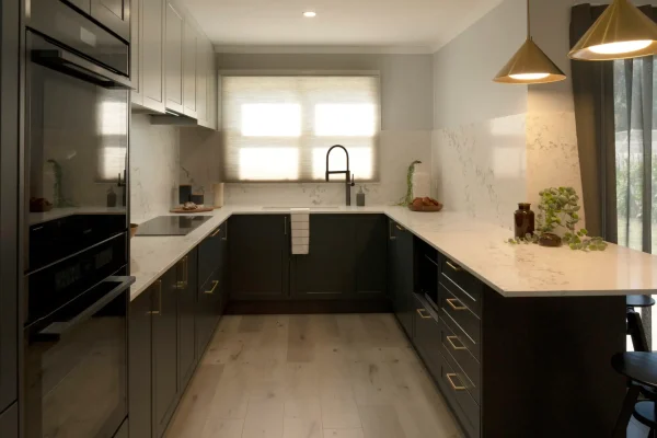 Galley kitchen featuring shaker style in terril and oyster colour overhead cabinetry with sink and tap in black and styling items on bench as featured on Selling Houses Australia in North Fitzroy