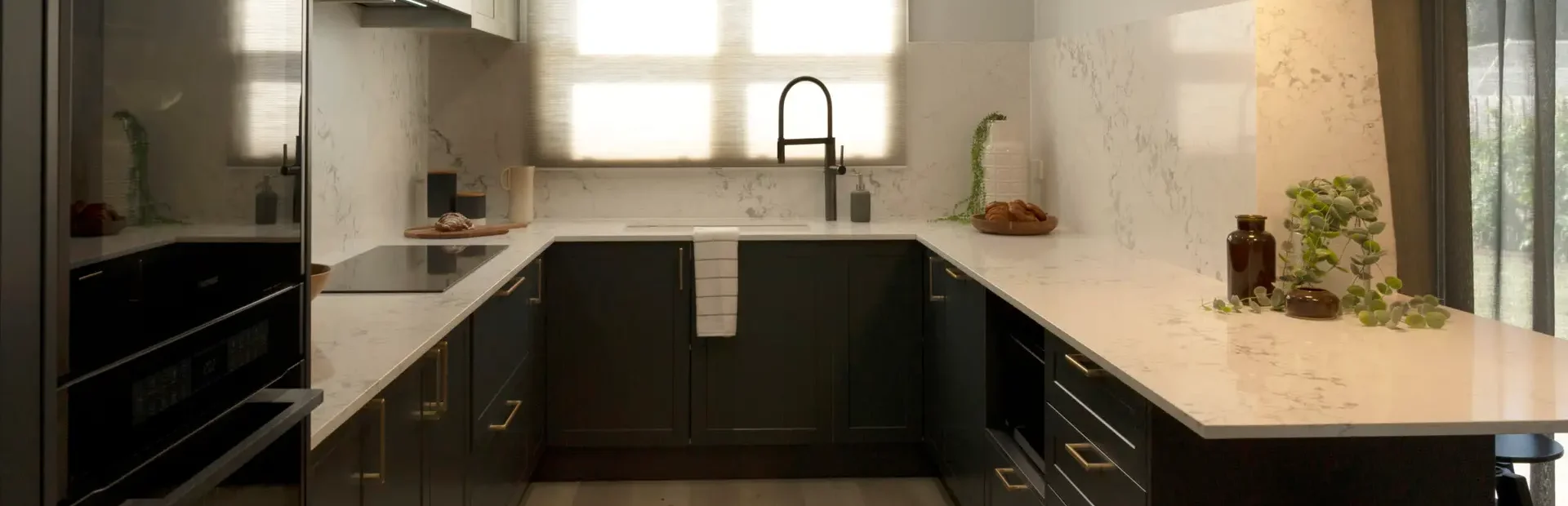 Galley kitchen featuring shaker style in terril and oyster colour overhead cabinetry with sink and tap in black and styling items on bench as featured on Selling Houses Australia in North Fitzroy